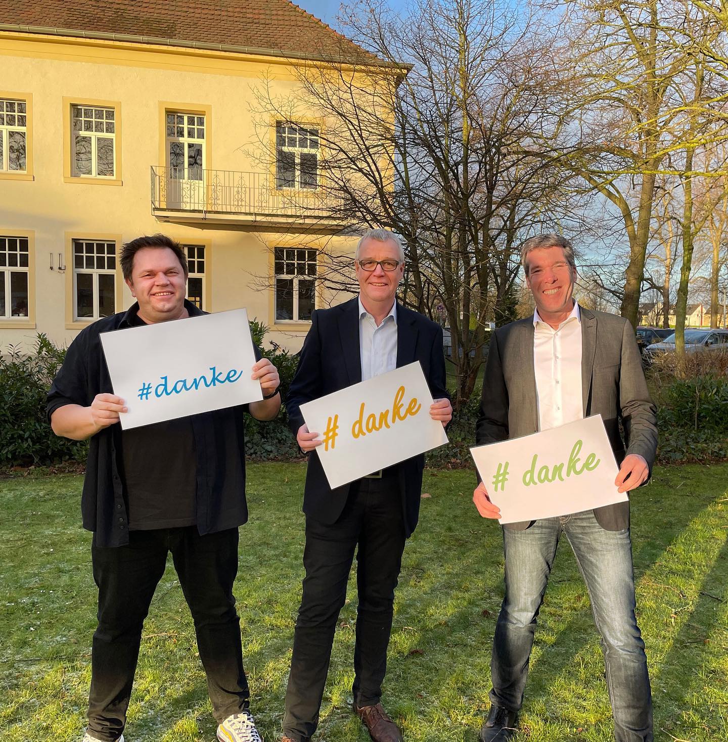 Adam Blana, Matthias Hopster, Rainer Klomp Drei Leitungskräfte stehen auf dem Alexianer Gelände mit einem Danke-Schild